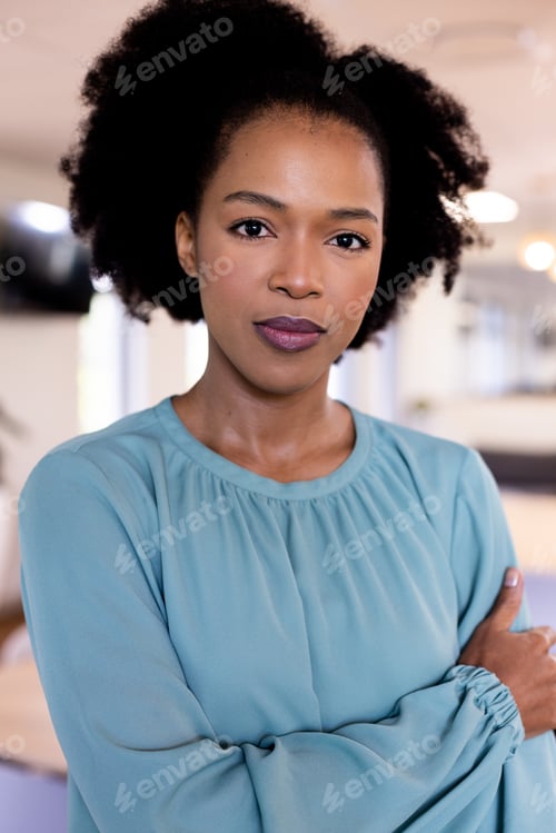 Preview: Portrait of african american businesswoman with arms crossed in modern office
