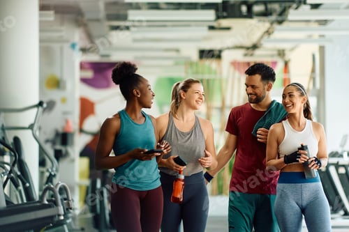 Preview: Group of happy friends talking after working out in a gym.