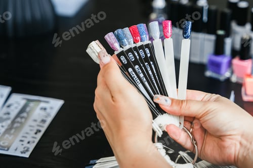 Preview: Multi-colored nail polish samples palette. Professional master manicurist at beauty salon.