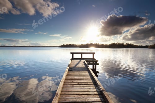Preview: sunshine over wooden pier on big lake