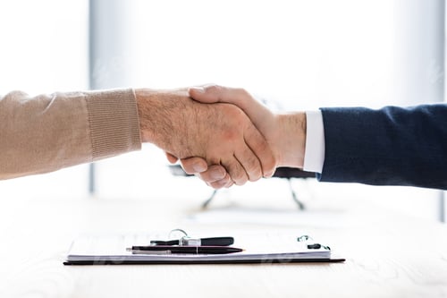 Preview: cropped view of man and car dealer shaking hands in office