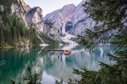 Preview: Wooden rowing boats at calm lake Braies or Pragser Wildsee during sunset pink light. Dolomites