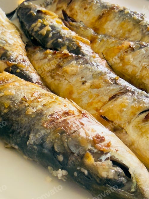 Preview: Grilled sardines cooking on a white plate enjoying seafood
