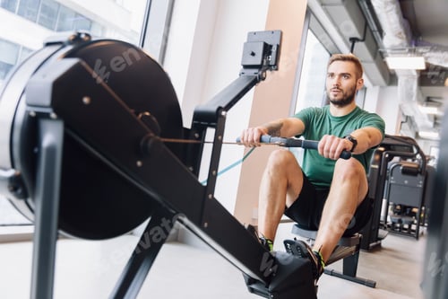 Preview: Active athlete man doing rowing workout