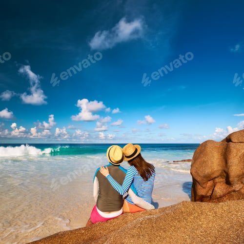 Preview: Couple On A Tropical Beach At Seychelles Wearing Rash Guard