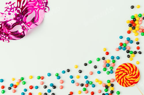 Preview: flat lay with arranged masquerade mask, lollipop and sweets isolated on white