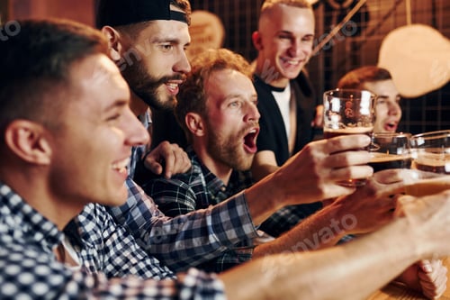 Preview: Fans cheer and shout. Group of people together indoors in the pub have fun at weekend time