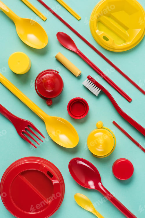 Preview: Flat lay with red and yellow disposable plastic wares arranged on blue background