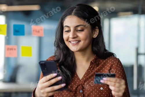 Preview: Businesswoman close-up inside office holding bank credit card and phone, office worker close-up