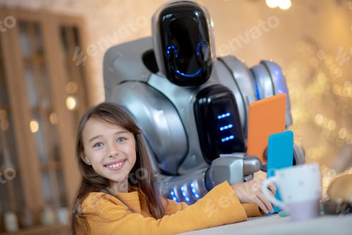 Preview: Robot with tablet and a smiling girl sitting at the kitchen
