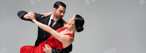 Preview: Man in suit performing tango with elegant partner isolated on grey, banner