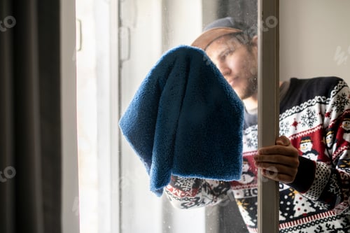 Preview: a person cleaning the window glass using microfiber