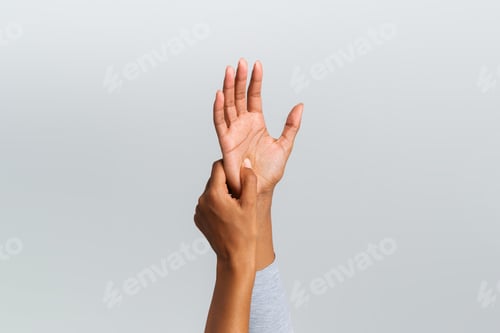 Preview: Black woman rubbing her painful palm, cropped