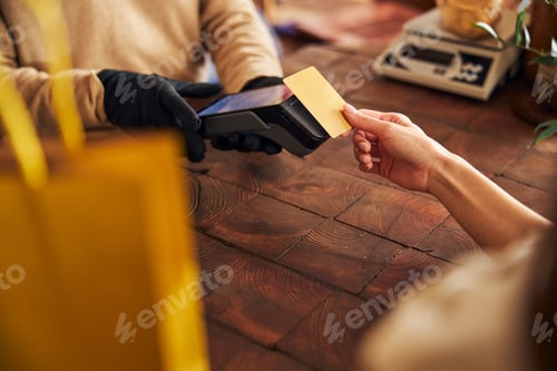 Preview: Young woman using credit card to pay for purchases
