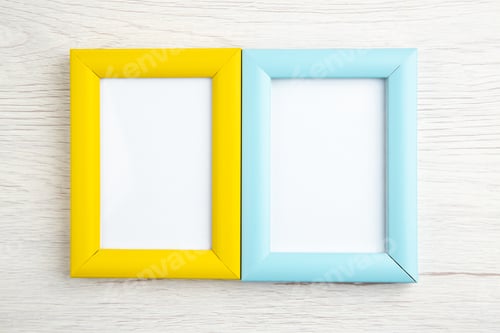 Preview: Above view of yellow and blue empty picture frames on white wooden stripped background