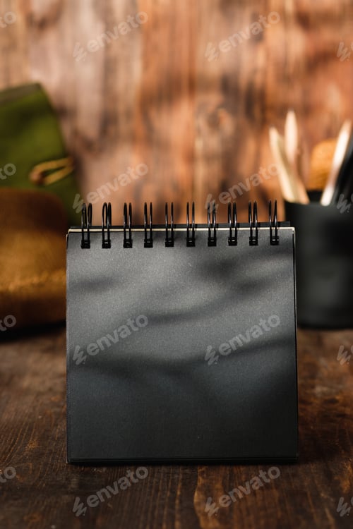 Preview: blank black sprial notebook diary with travel stuff on wood table