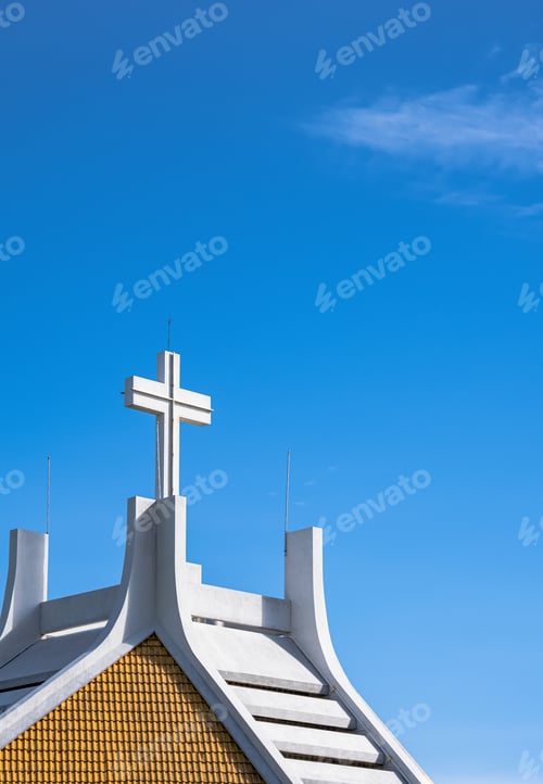 Vista previa: Large cross on rooftop of white church against blue sky background
