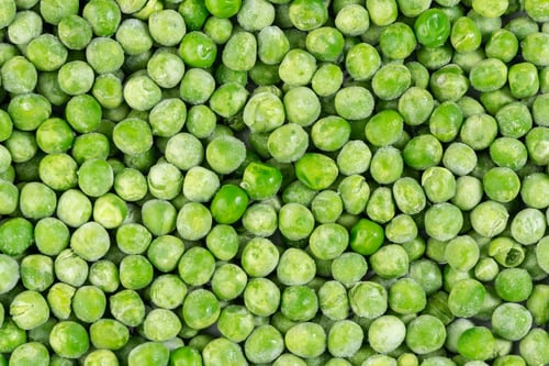 Preview: High angle closeup shot of a pile of frozen green peas