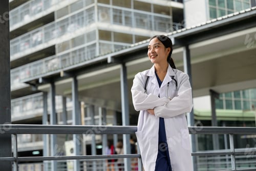 Preview: Confident Asian woman doctor smiling standing at hospital