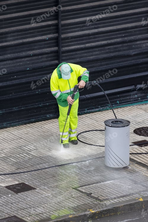 Preview: Worker cleaning a sidewalk with high pressure water jet machine