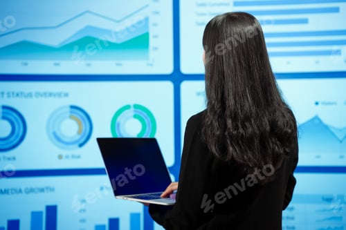 Preview: Asian businesswoman analyzing reports before digital dashboards evaluating import taxes consumer