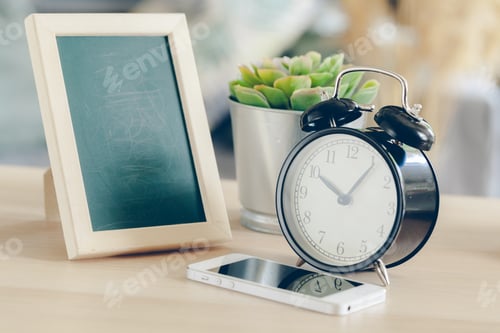 Preview: alarm clock with cell phone on a wooden table