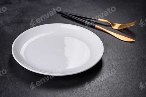 Preview: White plate on a black background. Flat lay, top view, copy space