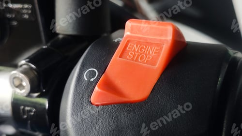 Preview: Red Engine Stop Switch on Black Surface with Rotational Arrow Symbol.