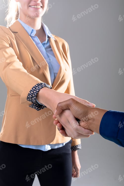 Preview: Midsection of caucasian and african american business people shaking hands on grey background