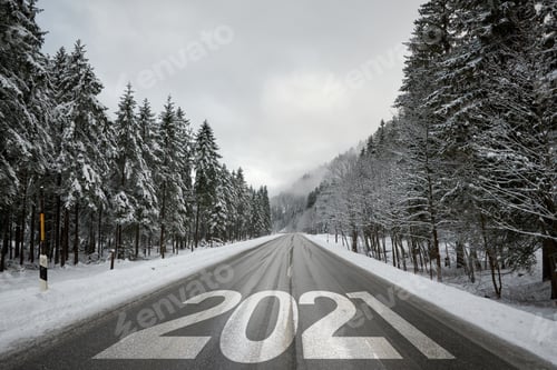Preview: Number 2021 on open road in winter. New year 2021 on empty road surrounded by snowy forest.