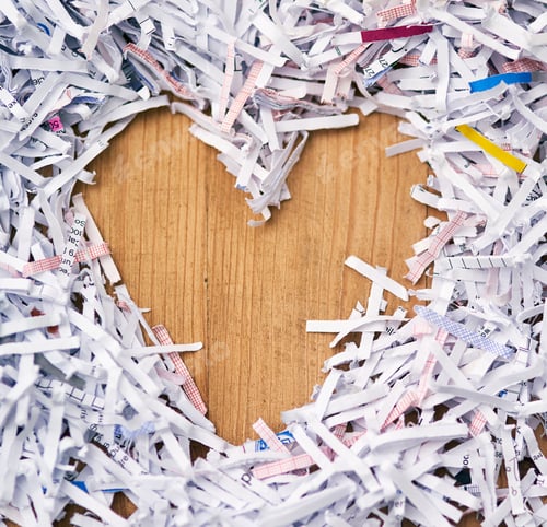 Preview: Studio shot of shredded paper arranged in the shape of a heart on a wooden table