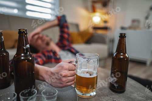 Preview: Young man drinking too much beer at home