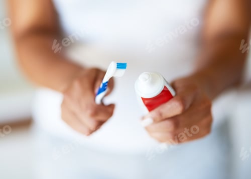 Preview: Protection for your pearly whites. Cropped shot of a woman putting toothpaste on a toothbrush.