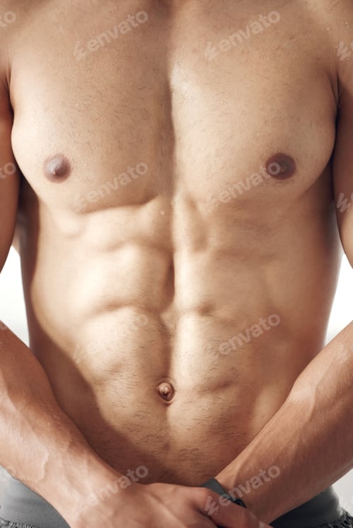 Preview: Closeup of one fit topless mixed race man with muscular hard six pack abs from regular exercise in