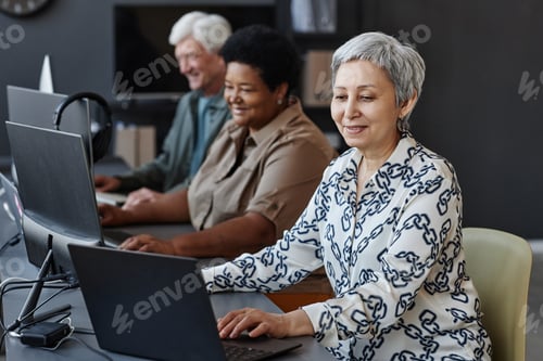 Preview: Senior Asian woman using computer in programming class for seniors