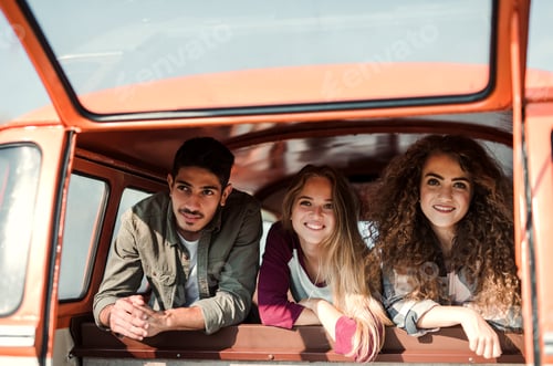 Preview: A group of young friends on a roadtrip through countryside, looking out of window.