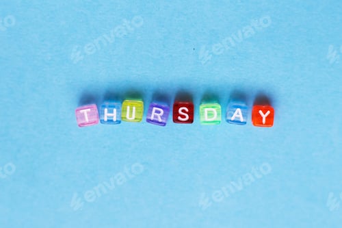 Preview: inscription thursday made by multicolor plastic cubes on a blue background.