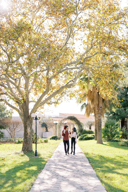 Preview: Dad with a little girl on his shoulders walks along the path in the park with mom