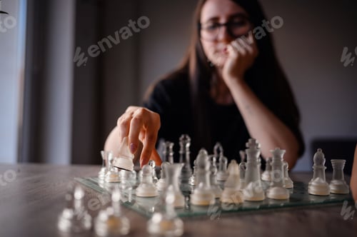 Preview: Woman Moving Glass Chess Piece During Intense Match