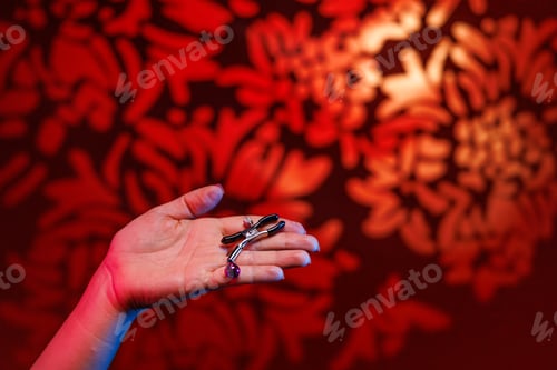 Preview: Feminine hands with a sexy red manicure grasp a nipple clamp for BDSM pleasure