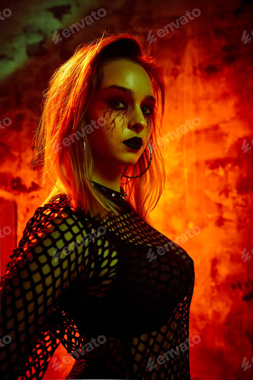 Preview: Female model in halloween outfit posing with on a red background. Gorgeous girl in clothes