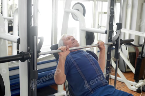 Preview: Elderly male is having intense workout in gym