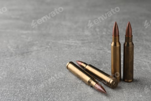 Preview: Bullets on light grey table, closeup. Space for text