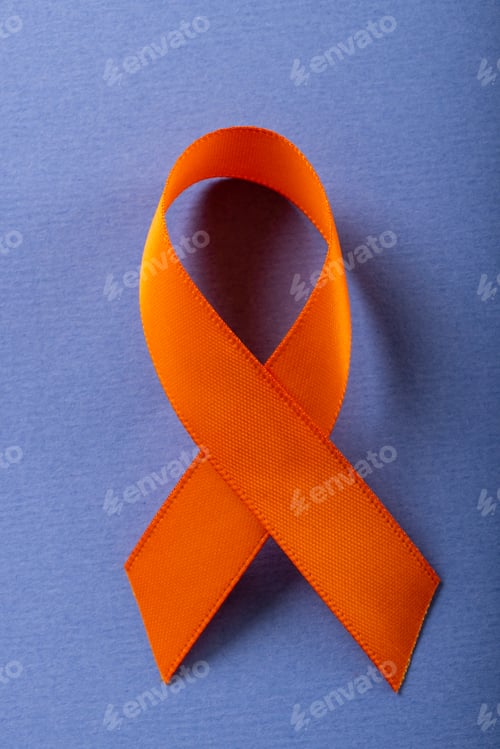 Preview: Close-up of orange leukemia awareness ribbon isolated against blue background, copy space