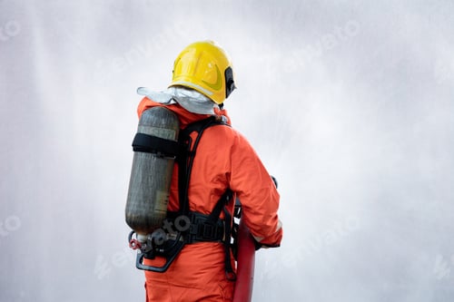 Preview: Fireman wearing firefighting suite using fire extinguisher fighting fire equipment and accessories i