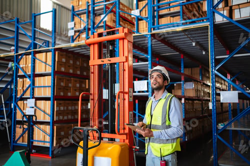 Preview: Professional warehouse workers using digital tablet with forklift and pallets.