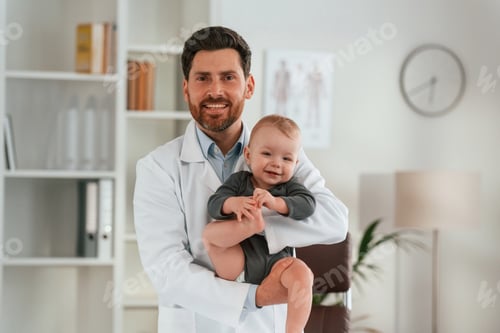 Preview: Holding boy in hands. Doctor with little baby is working in the cabinet