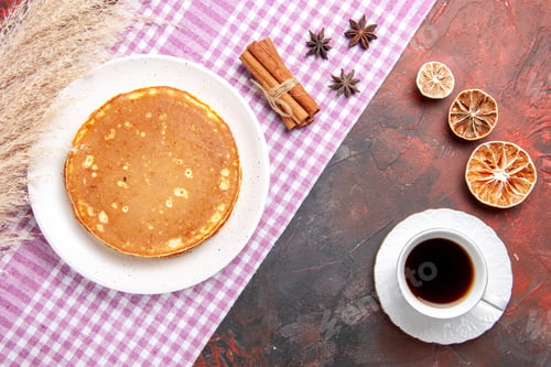 Preview: Top view tasty pancakes on a pink stripped towel and tea on mixed color table