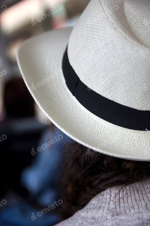 Preview: Back view at young woman with white hat