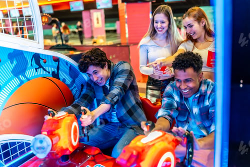Preview: Friends playing arcade basketball game together in bowling alley